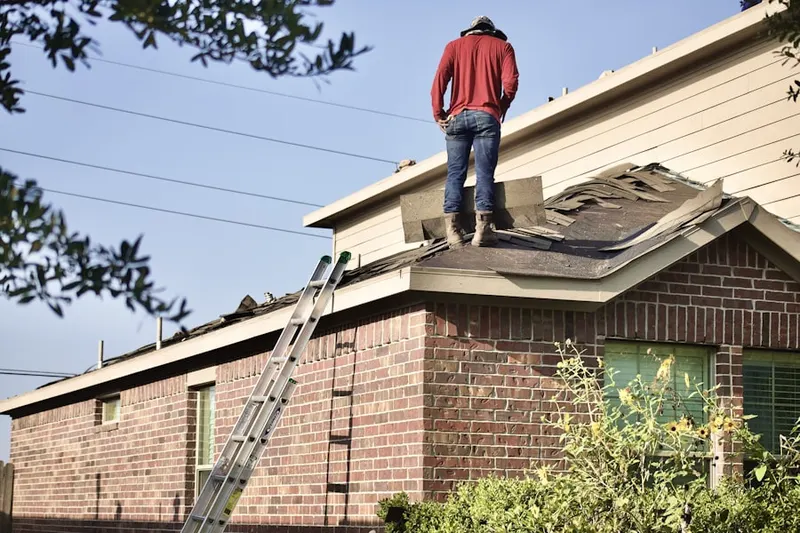 Professional roofer working on a residential roof in Juntunen Acres
